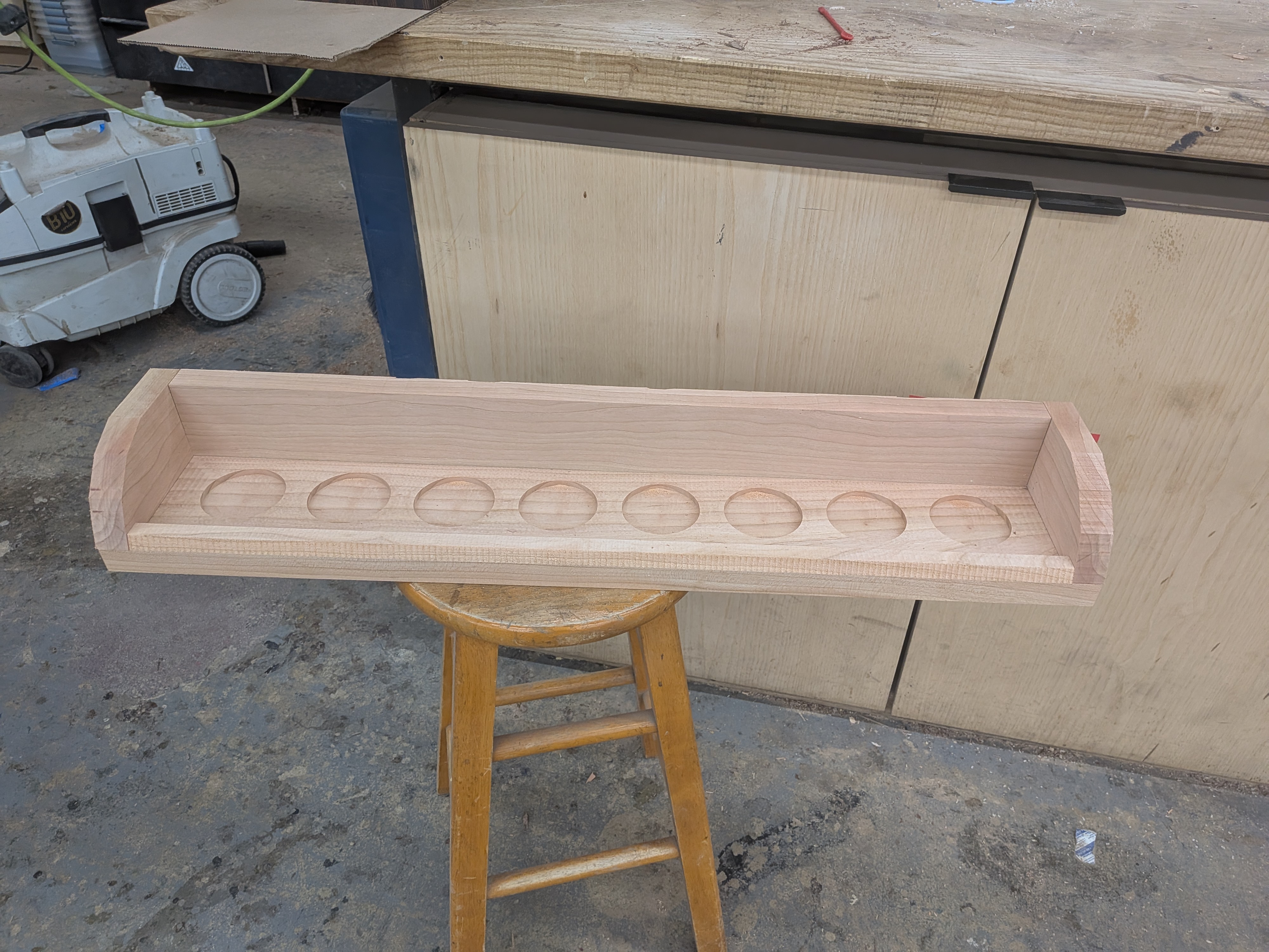Display fresh off the CNC — unfinished walnut showing all 8 pockets and front lip
