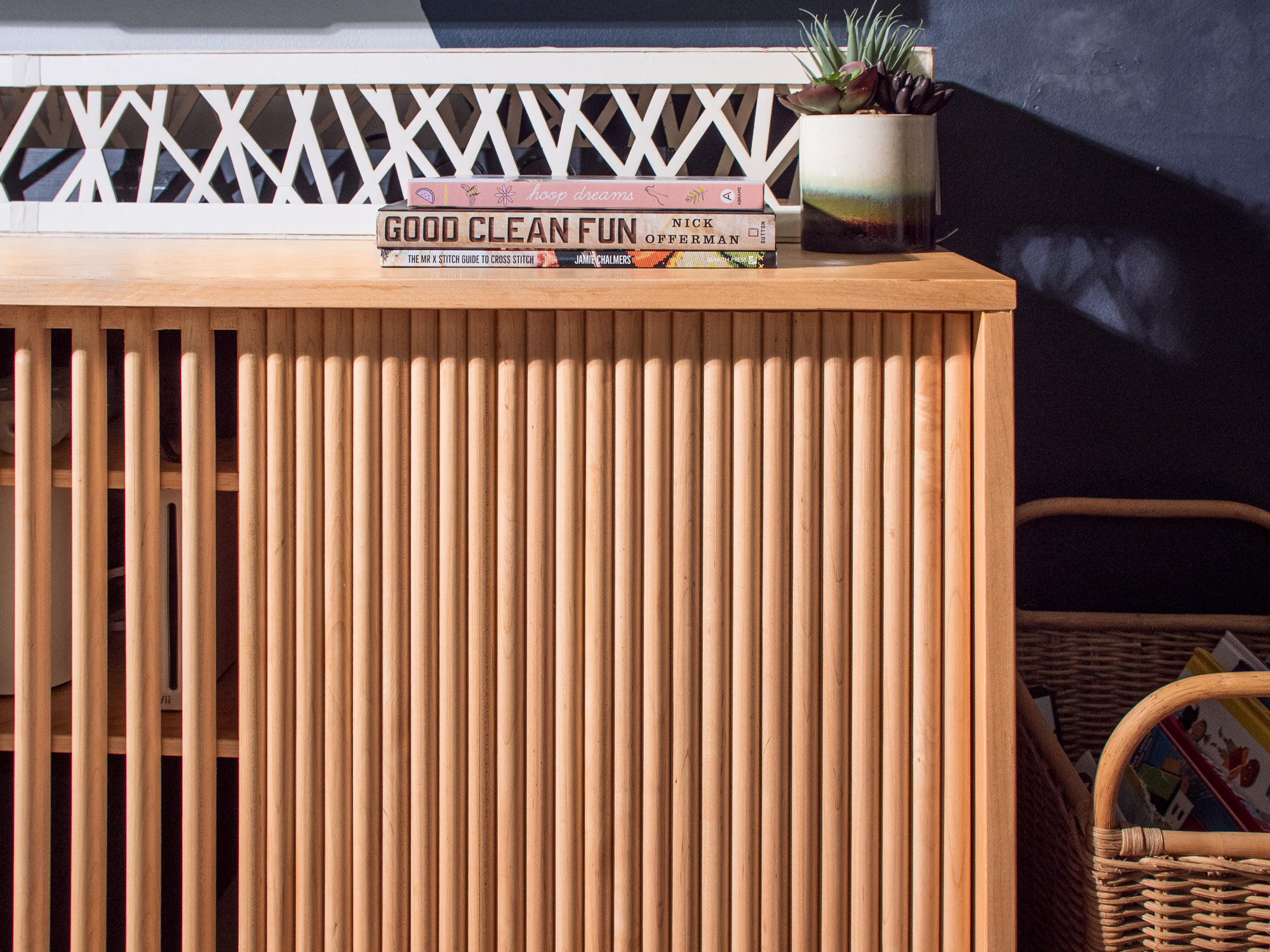 Close-up of the right side of the console — fluted dowels in warm raking light